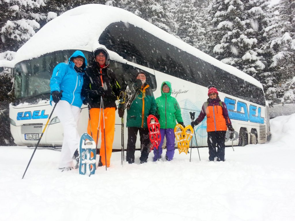 Glückliche Reisende in Winterkleidung, lächelnd, im Schnee. 